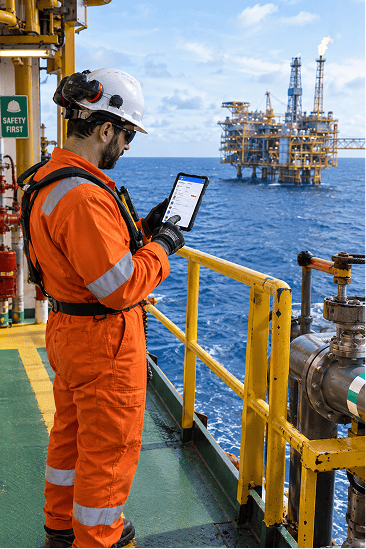 Oil and gas worker on offshore platform using the Skali telehealth app on a tablet to consult an emergency physician